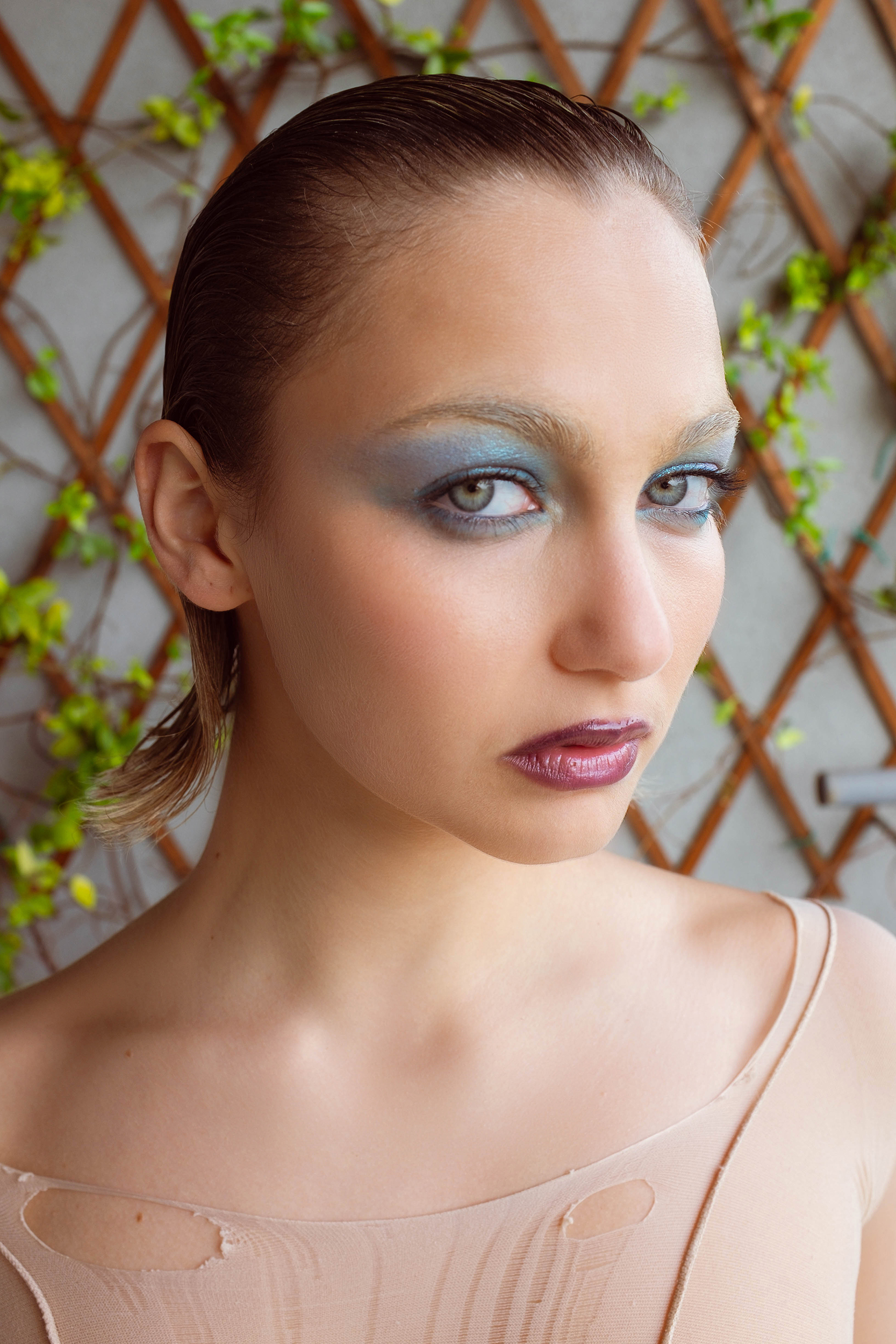 a woman with blue eyes and purple lipstick