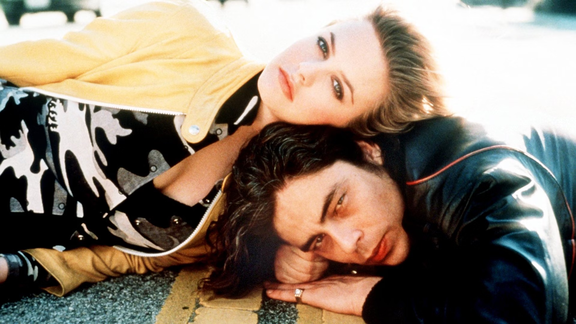 Alicia Silverstone and Benicio del Toro lying on the ground